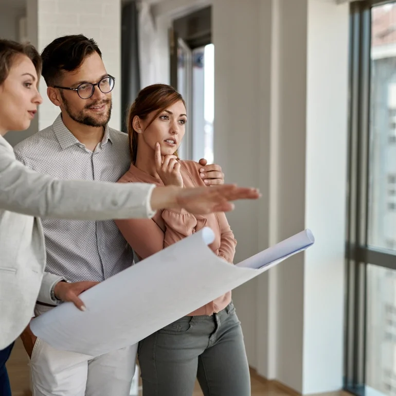 personas mirando un plan de una casa